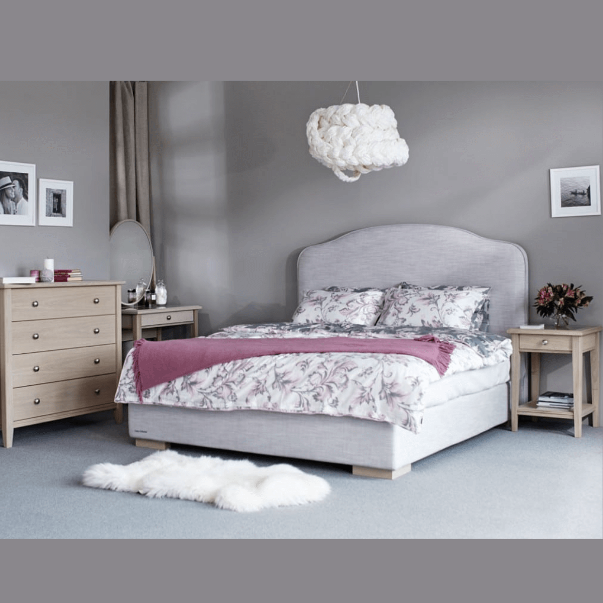 Customized bed with floral bedding, nightstands, and decorative elements in a modern bedroom setting.